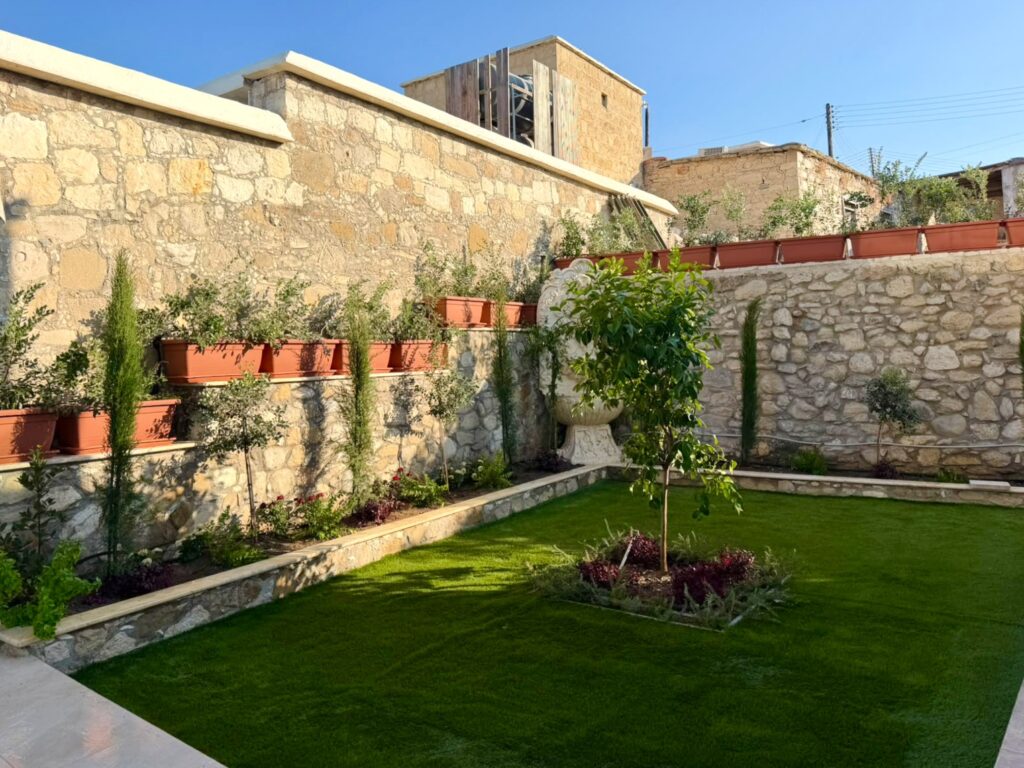 Stone Wall Sanctuary: Premium Synthetic Turf & Tiered Softscape Construction